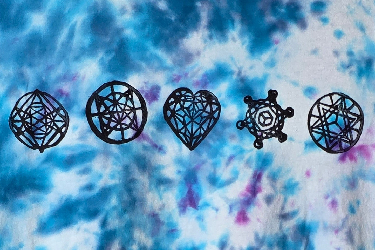 Black geometric symbols on a tie-dye background with blue and purple hues