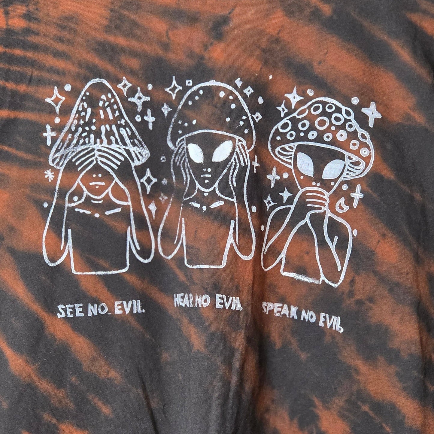 Tie-dye shirt with white graphic design and text on a black and orange background
