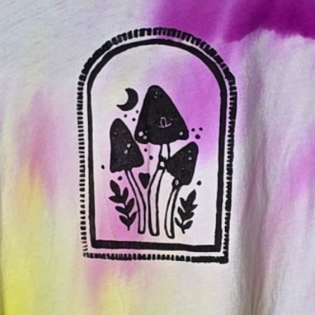 Black mushroom design on a tie-dye background with purple and yellow colors.