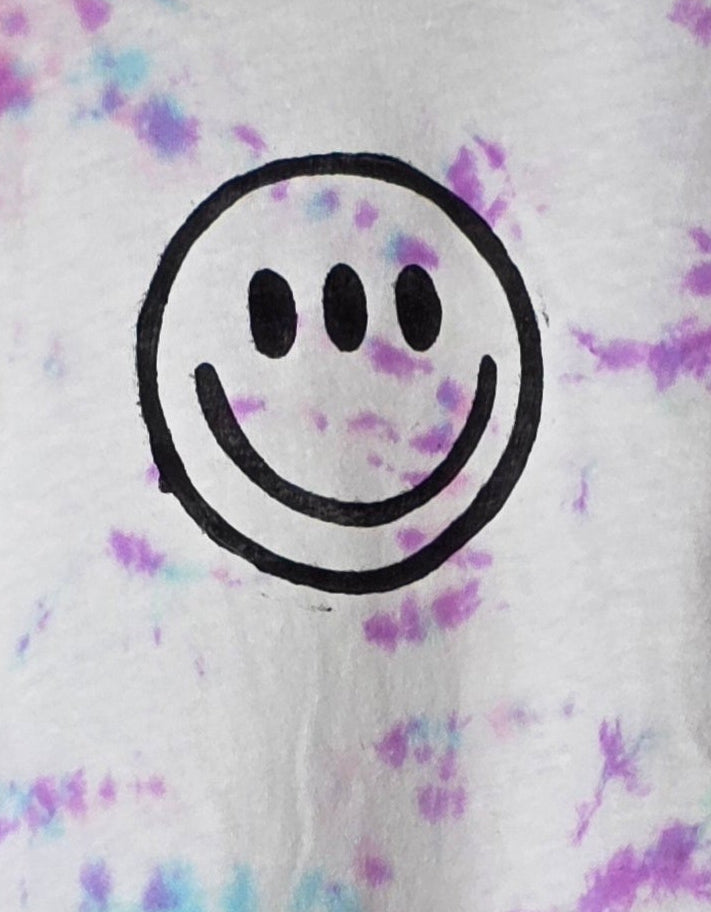 Black smiley face on a tie-dye background with purple and blue patterns