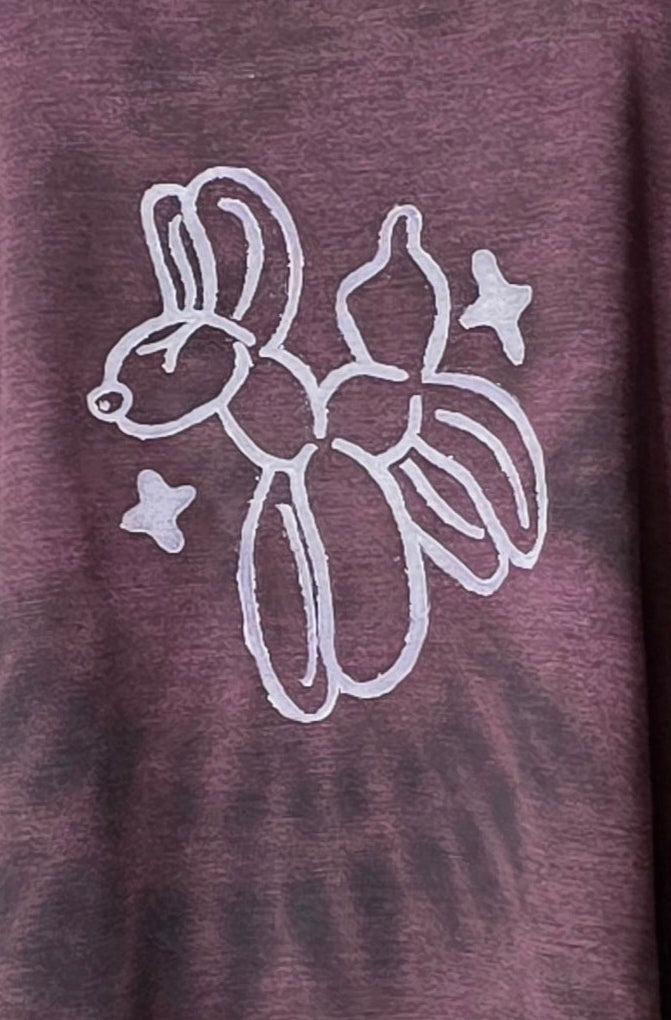 Maroon bleach dyed t-shirt with white balloon animal design and stars on a plain background