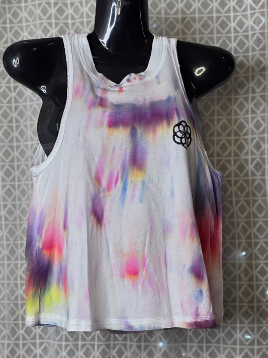 Colorful tie-dye tank top on a mannequin against a patterned wall.