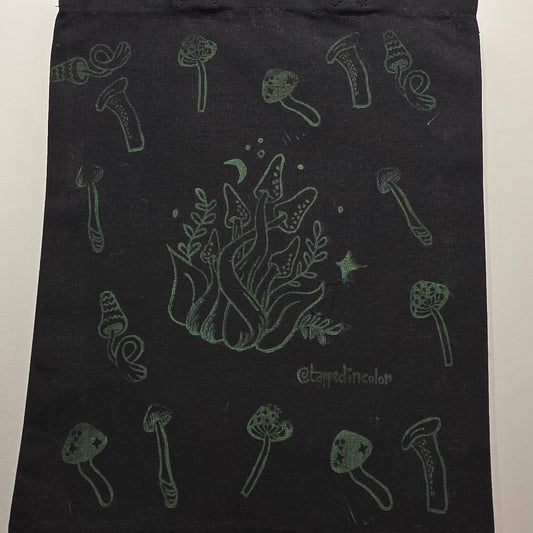 Black tote bag with green illustrations on a white background