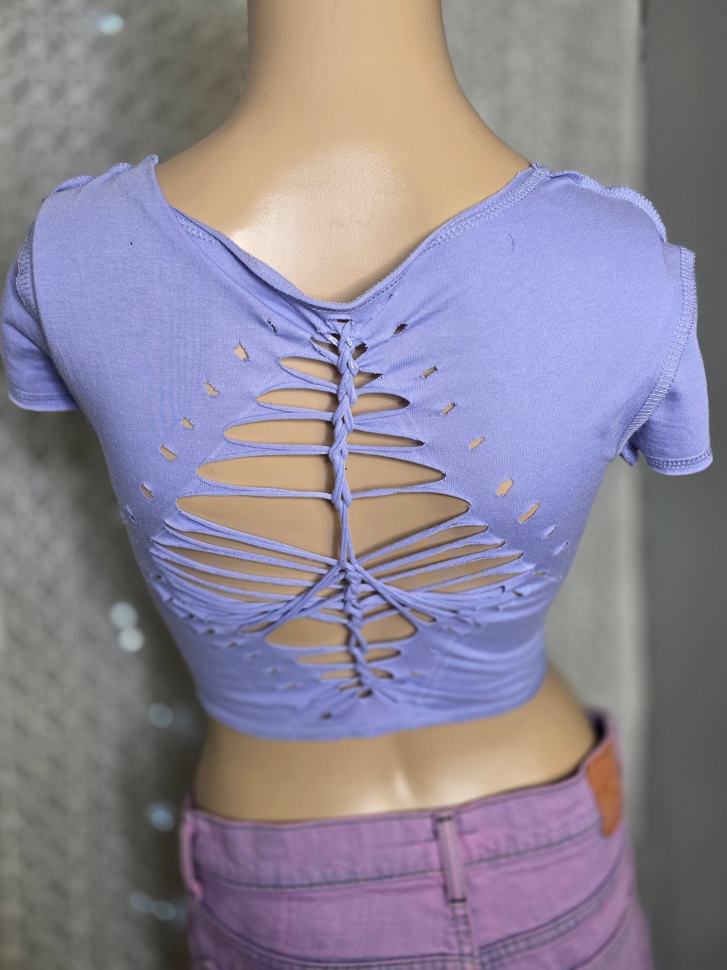 Purple sports bra with cut-out design worn by a person on a neutral background