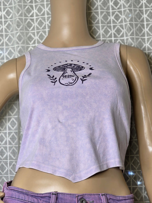 Mannequin wearing a light purple tank top with a graphic design on a tiled floor background