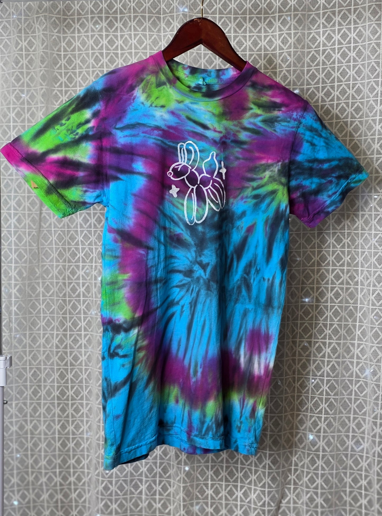 Tie-dye t-shirt with a white graphic on a textured wall background