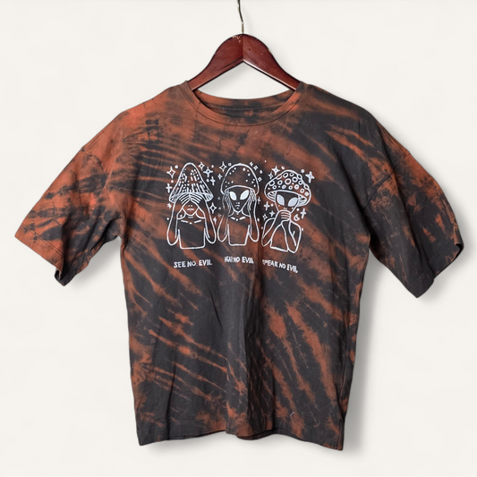 Tie-dye t-shirt with alien graphic design on a hanger against a white background