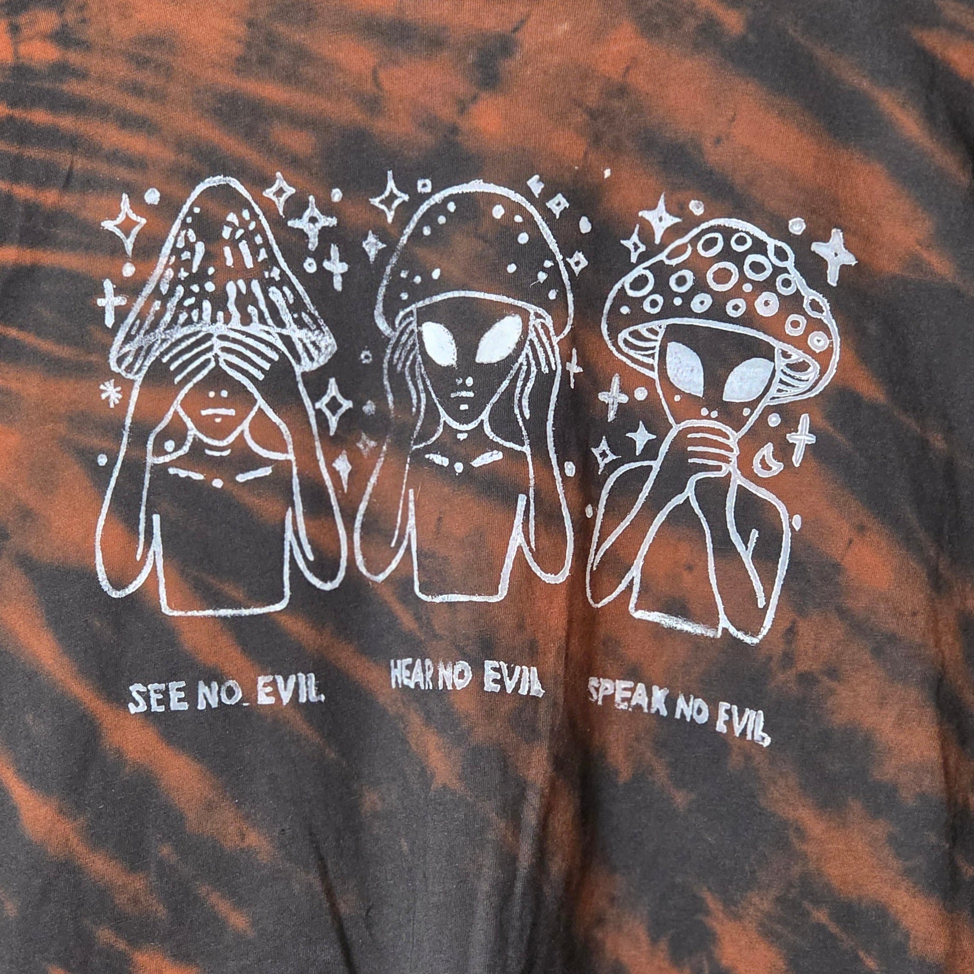 Tie-dye shirt with white graphic design and text on a black and orange background
