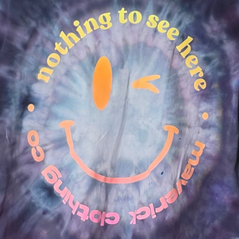 Tie-dye t-shirt with smiley face and text on a hanger