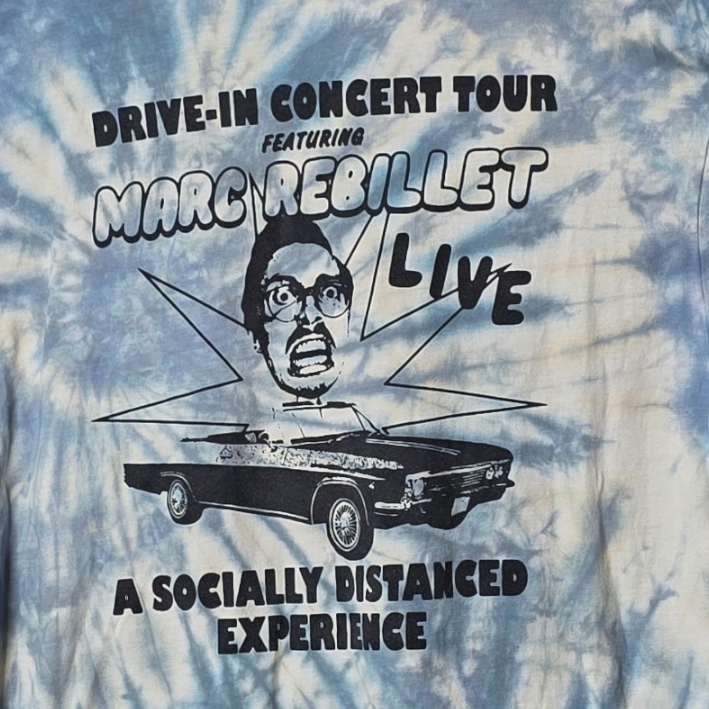 Tie-dye t-shirt with concert tour graphic on a hanger