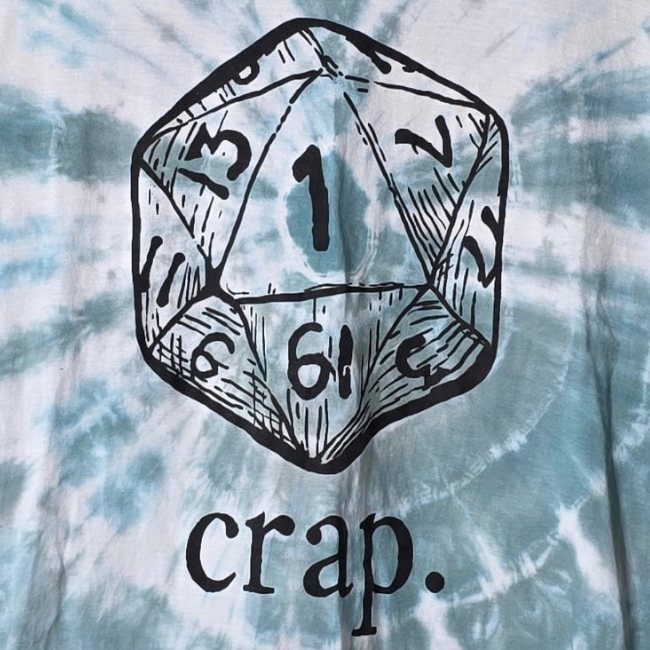D20 dice with numbers and 'crap.' text on tie-dye fabric