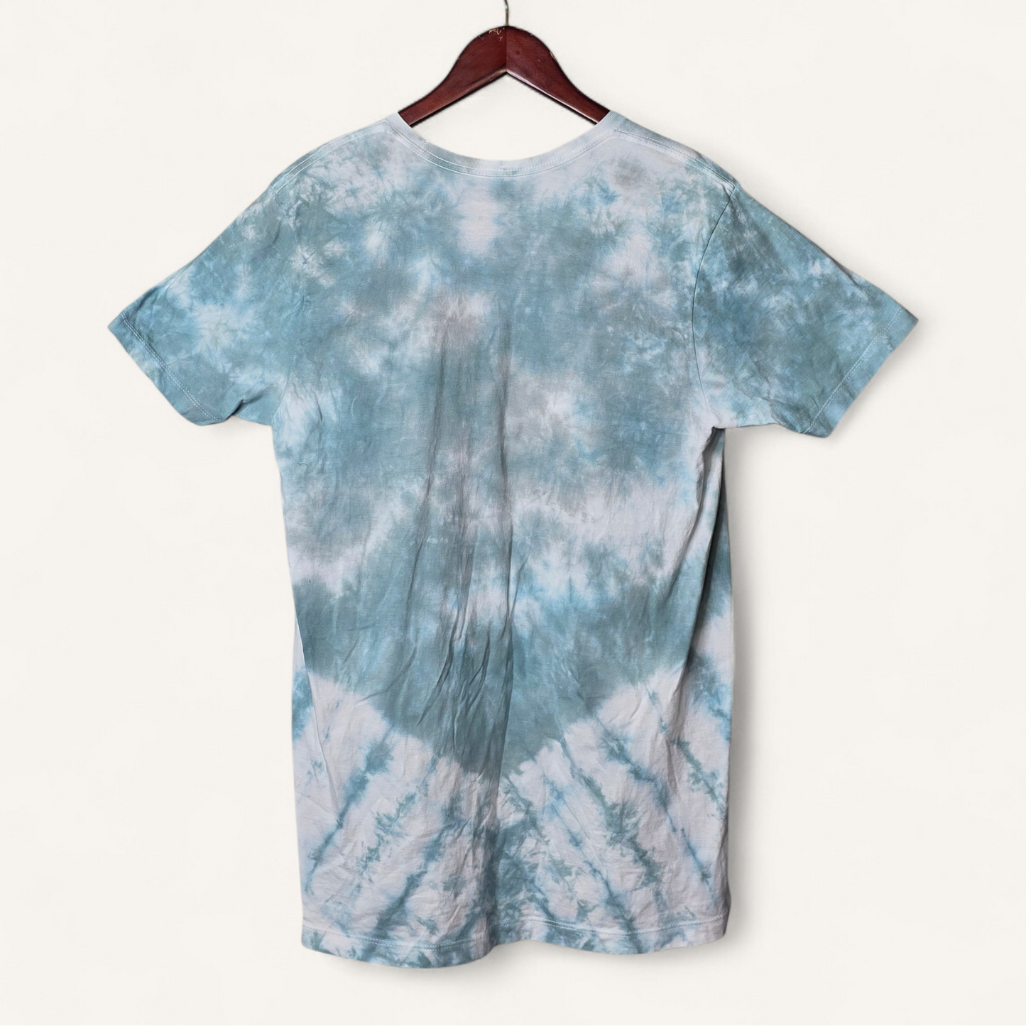 Blue and white tie-dye t-shirt on a hanger against a white background