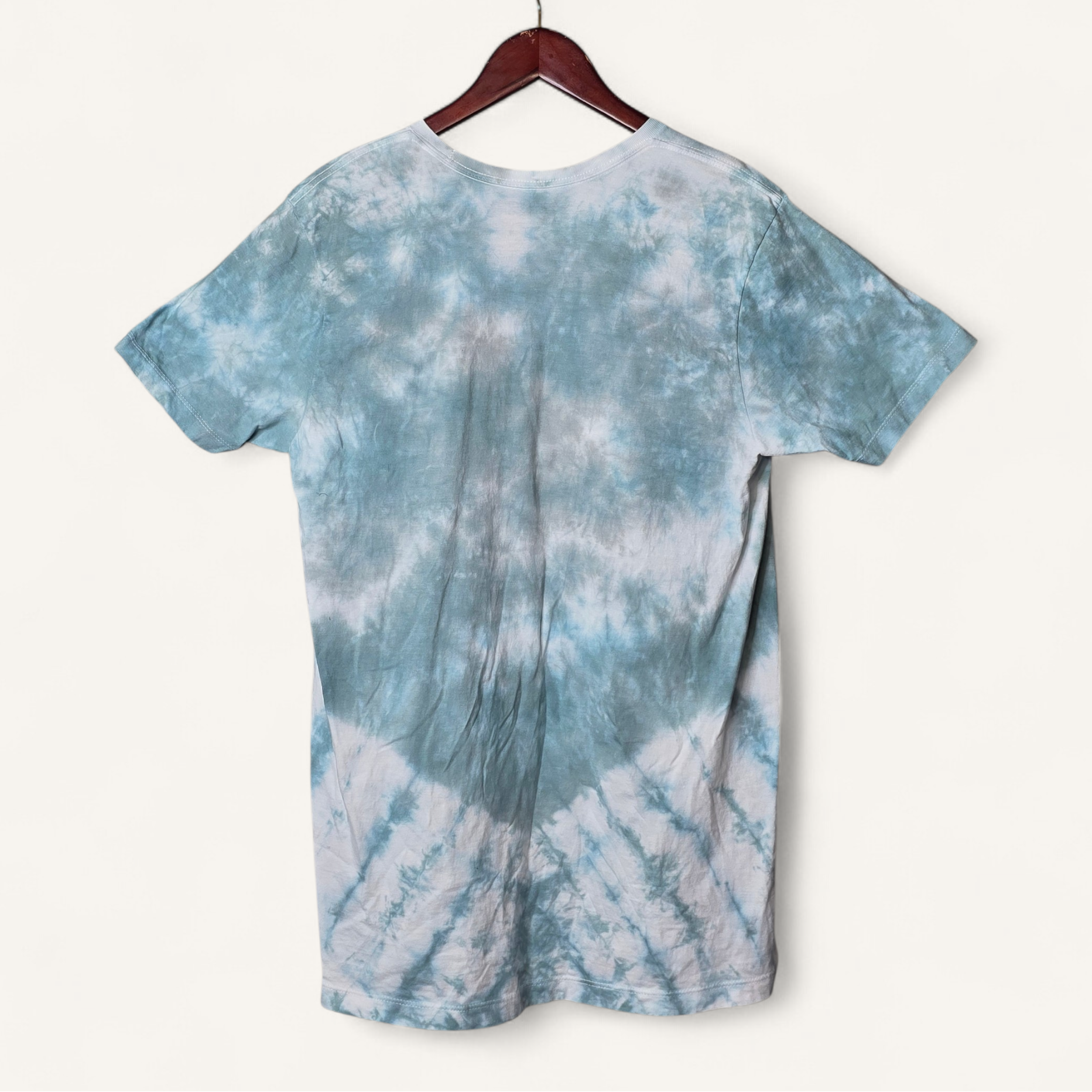 Blue and white tie-dye t-shirt on a hanger against a white background