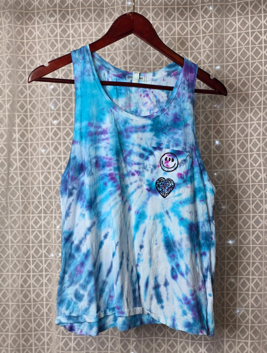 Tie-dye tank top with a heart and smiley face design on a hanger against a tiled wall.