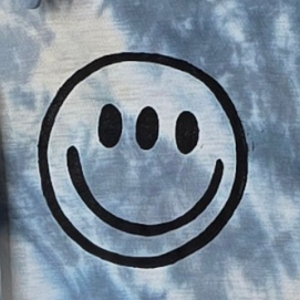 Tie-dye polo shirt with a circular design on a hanger against a white background