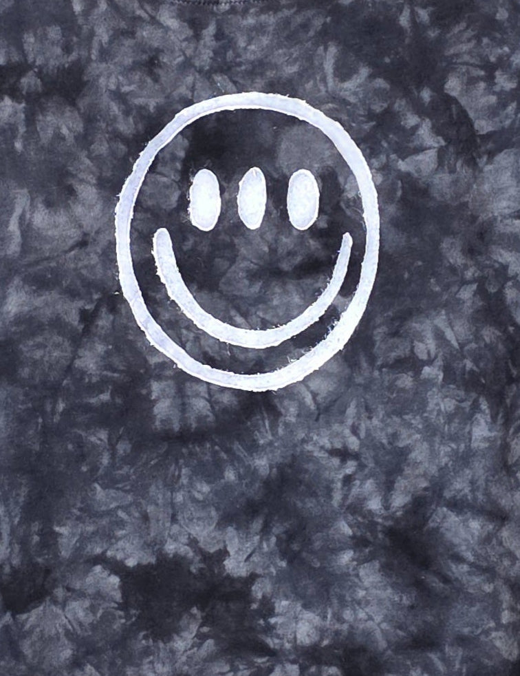 Tie-dye t-shirt with a white smiley face design on a dark background