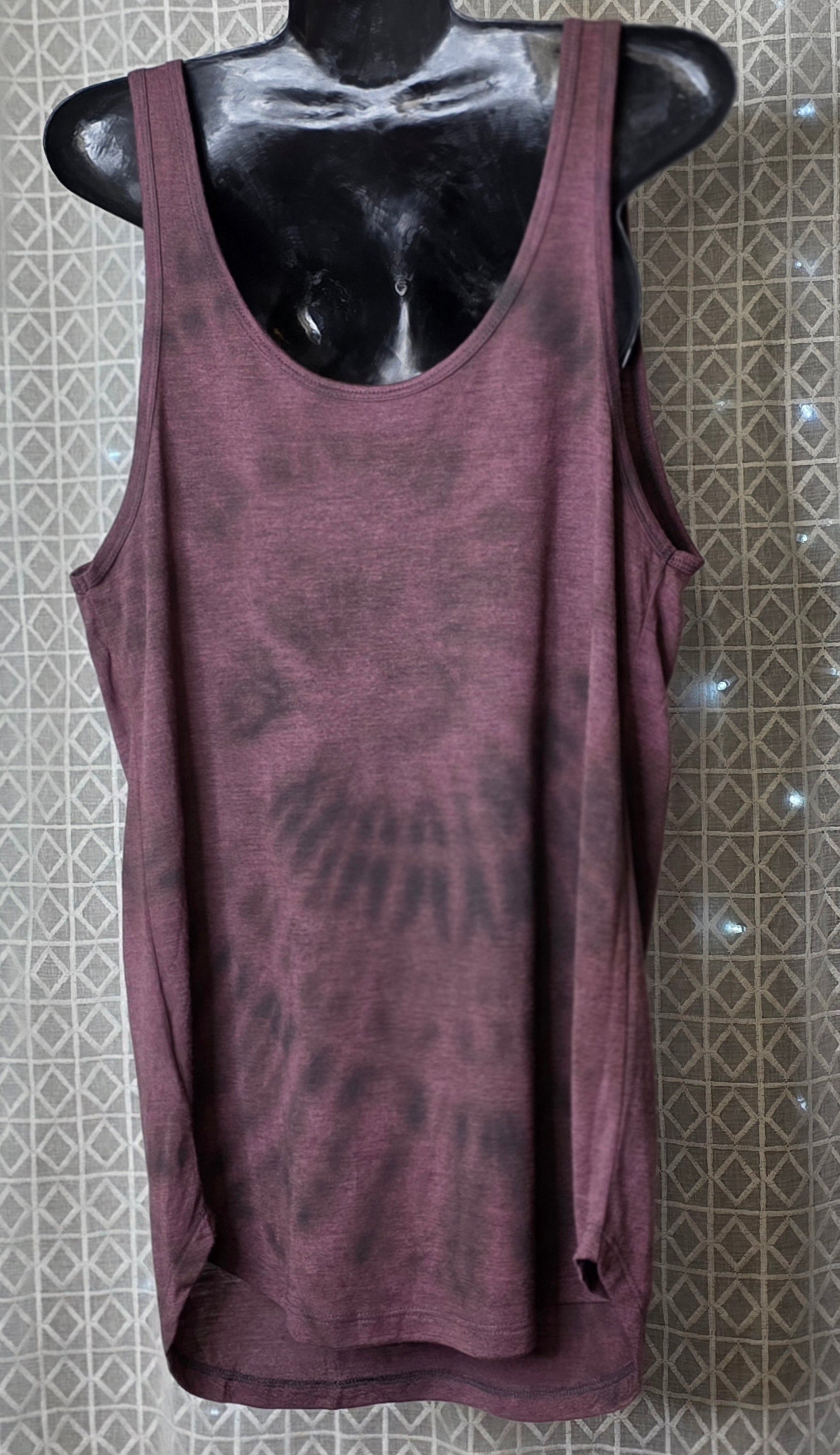 Bleach tie-dye tank top on a mannequin against a patterned wall.