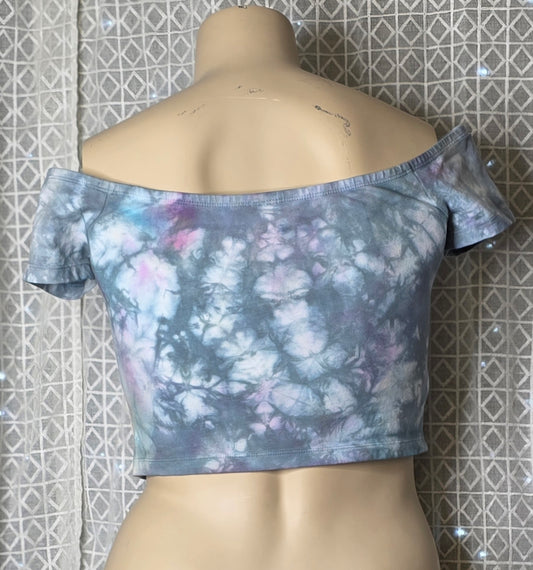 Floral off-shoulder top on a mannequin against a tiled wall.