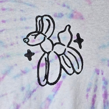 Tie-dye t-shirt with a black graphic on a hanger against a white background