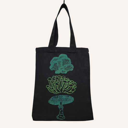 Black tote bag with teal mushroom illustrations on a white background