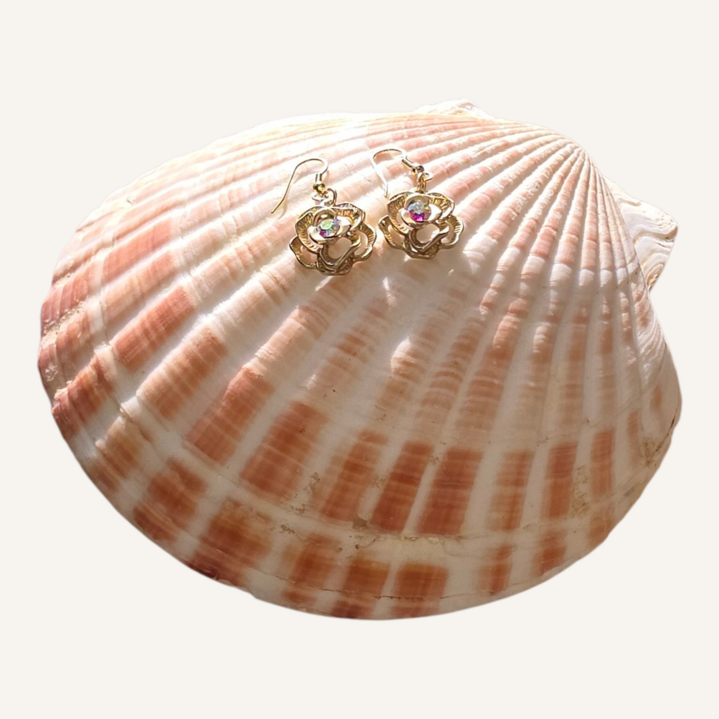 Shell with gold earrings on a white background