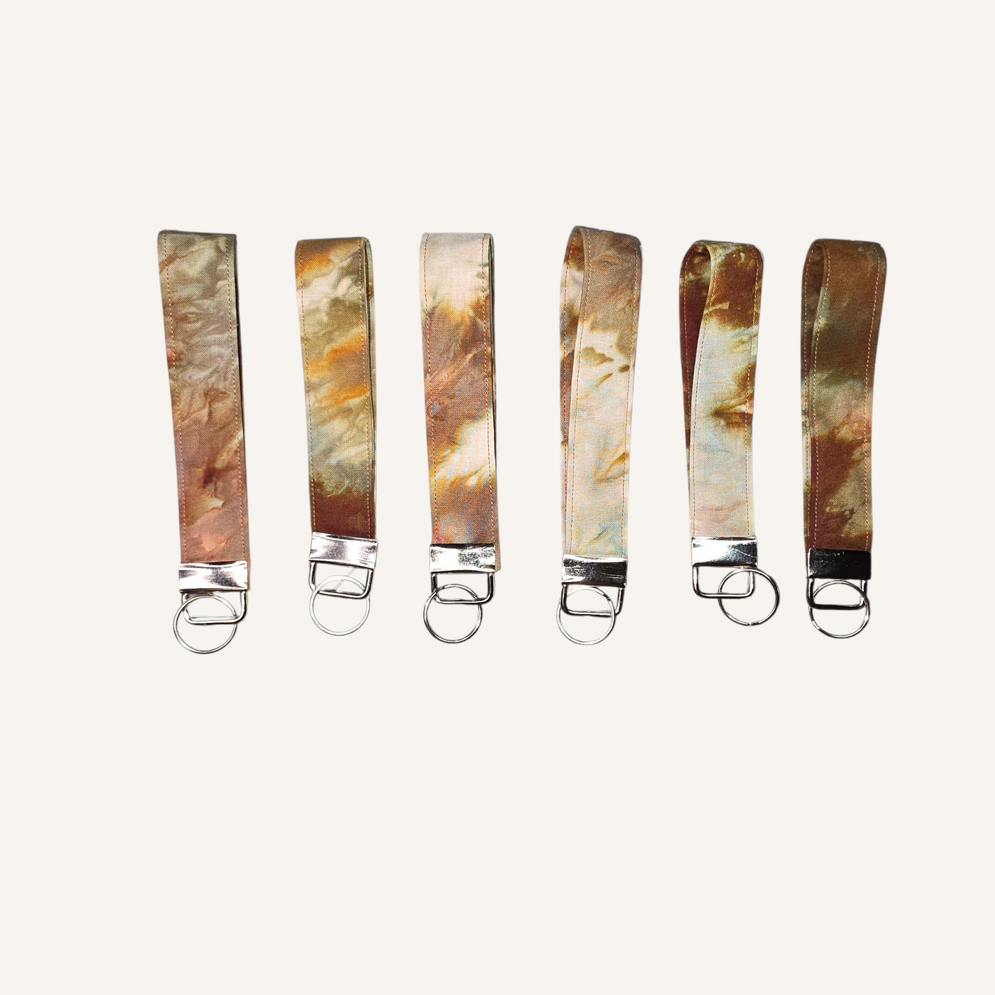 Set of six keychains with marble-like designs on a white background