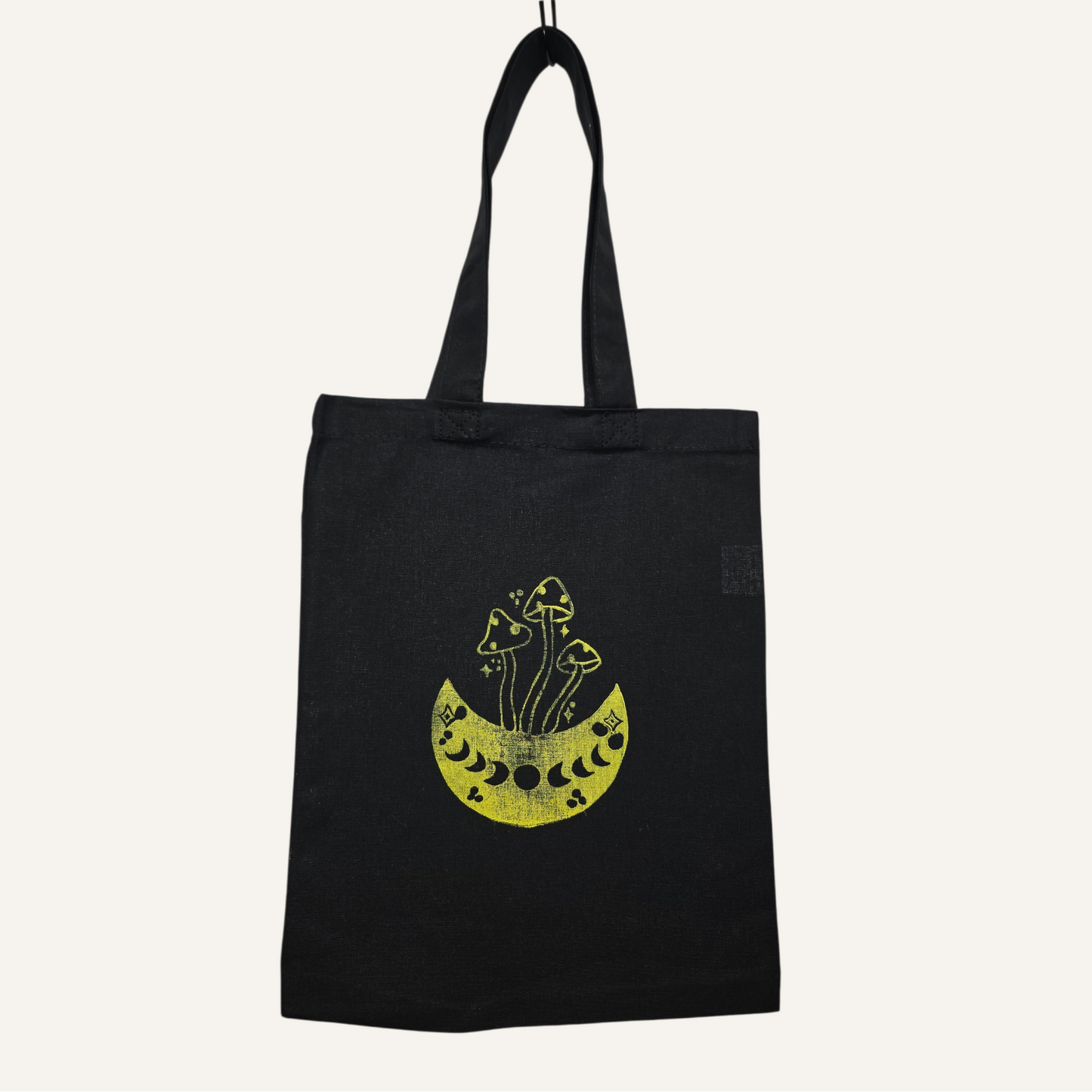 Black tote bag with yellow graphic design on a white background