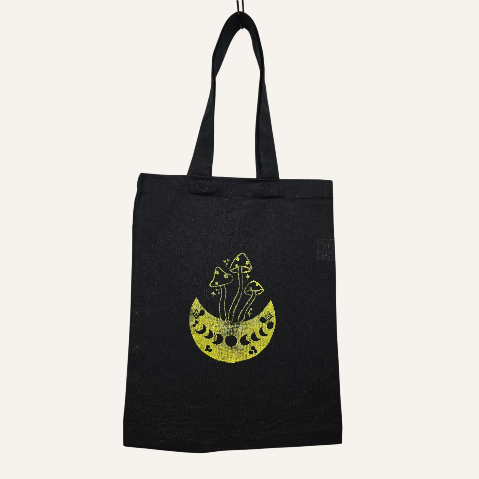 Black tote bag with yellow graphic design on a white background
